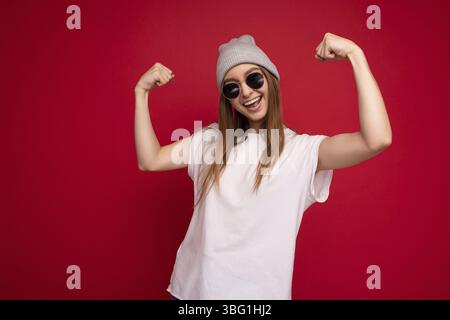 Portrait Foto von jungen emotionalen positiv glücklich schöne attraktive dunkelblonde Frau mit aufrichtigen Emotionen tragen lässige weiße T-Shirt mit leer Stockfoto