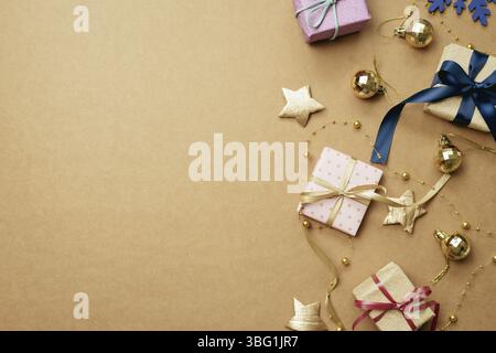 Weihnachtsschmuck und Geschenkbox auf braunem Hintergrund. Weihnachtsdekoration im Winter. Flach liegend, Draufsicht, Kopierbereich Stockfoto