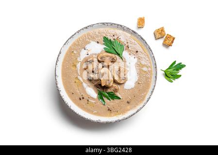 Pilzcremesuppe in der Schüssel mit Croutons und Petersilie isoliert auf weißem hölzernem Hintergrund, Draufsicht, Designelement. Champignon Mushro im Herbst Stockfoto