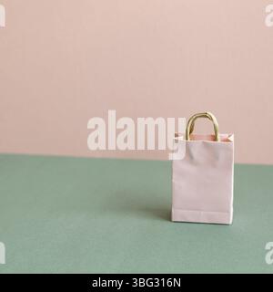 Papier-Einkaufstasche auf grünem und pinkem Hintergrund. Mit Kopierplatz Stockfoto