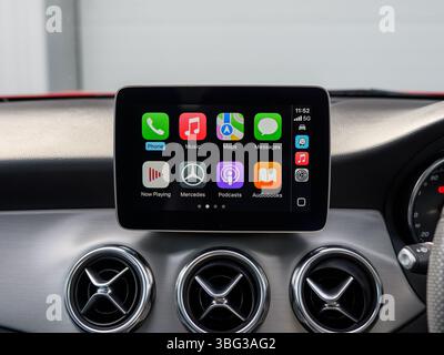 Diese Abbildung zeigt Apple CarPlay auf einem Infotainment-Bildschirm moderner Autos, mit App-Symbolen, die eine nahtlose Integration des Smartphones ermöglichen Stockfoto