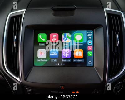 Diese Abbildung zeigt Apple CarPlay auf einem Infotainment-Bildschirm moderner Autos, mit App-Symbolen, die eine nahtlose Integration des Smartphones ermöglichen Stockfoto