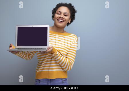 Kluge afro-brünette lateinamerikanische junge Bürofrau mit Laptop Stockfoto