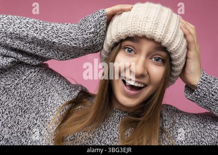 Nahaufnahme Foto-Porträt von schönen attraktiven ziemlich positiv glücklich erstaunlich lustig fröhlich junge blonde Frau trägt lässige grauen Pullover und beige Hut Stockfoto