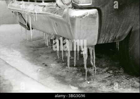 1973 Foto von A.V. Shirk, das Eiszapfen zeigt, die sich im Winter in Ohio auf der Stoßstange eines Autos bilden. Das Bild dokumentiert kalte Witterungsbedingungen und ist Teil von Shirks Arbeit, die den Alltag einfängt. Stockfoto