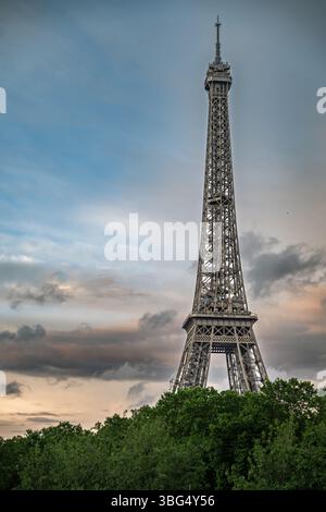 Ein malerischer Blick auf den Eiffelturm, der über der seine in Paris ragt, mit Booten, die am Ufer angedockt sind, und einem lebhaften Himmel über dem Ufer. Stockfoto