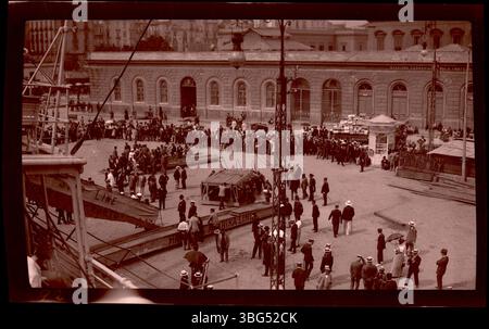Dieses Foto vom Juni 1913 zeigt Gangplanken für Passagiere und Gepäck, die für den Ausstieg von der S.S. Canopic im Hafen von Neapel arrangiert wurden. Die Arrases reisten an Bord der Canopic während ihrer Europatour in diesem Jahr. Dieses Foto dokumentiert die Ankunft am Hafen und ist Teil einer größeren Sammlung von Bildern, die Edmund F. Arras während seiner Reisen durch Europa aufgenommen hat. Stockfoto