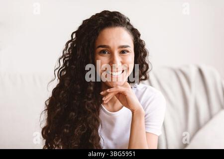 Nahaufnahme Porträt der dunkelhaarigen lockigen Frau posiert zu Hause Stockfoto