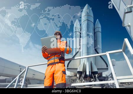 Professioneller Luft- und Raumfahrtingenieur, der in einer Raketenladefläche mit Laptop für die Steuerung arbeitet. Techniker der Space Shuttle-Station Stockfoto