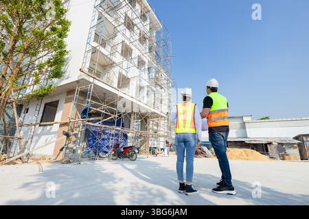 Rückansicht Bauingenieur, Architekt arbeitet auf der Baustelle zusammen. Bauarbeiterplanung auf der Baustelle. Stockfoto