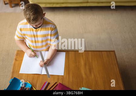 Metalllineal zur Führung der grünen Bleistiftmarkierung auf dem Kaffeetisch, mit blauem Bleistiftetui Stockfoto