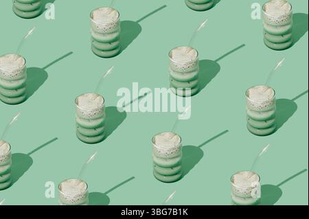 Kreatives Sommermuster aus gefrorenem Matcha-Latte auf pastellgrünem Hintergrund. Minimales gesundes Matcha Latte Konzept. Trendige Drink-Idee. Stockfoto