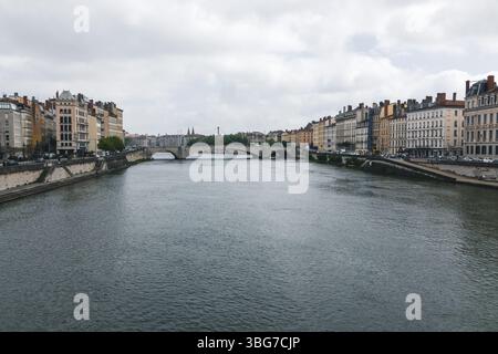 Eine wunderschöne Aussicht auf den Fluss Saône im Zentrum von Lyon, mit einer malerischen Brücke und traditionellen Gebäuden auf beiden Seiten. An einem bewölkten Tag. Stockfoto