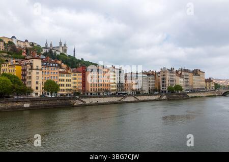 Gebäude entlang des Flusses Saône und der Altstadt von Lyon, mit Blick auf den Hügel Fourvière mit seiner Basilika, einem herausragenden Merkmal der Skyline der Stadt. Stockfoto