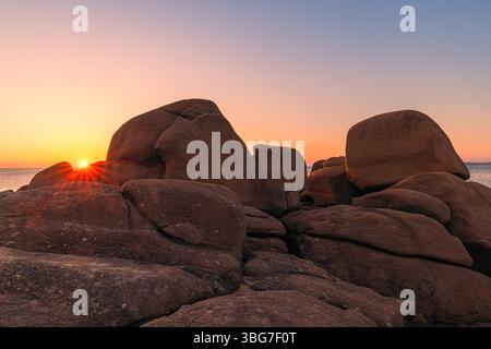 Sonnenuntergang entlang der Côte de Granit Rose (Rosa Granitküste), wo wunderschöne Felsformationen aus glänzenden rosa Granitfelsen ein wunderschönes Zusammenspiel mit bilden Stockfoto