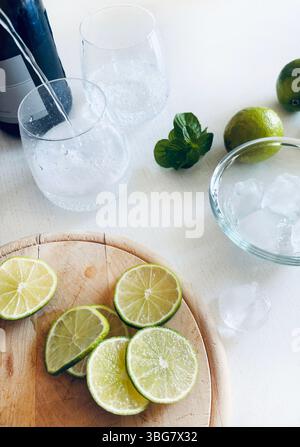 Hugo Spritz Cocktail Drink mit Prosecco oder Sekt, Limette, Minzblättern und Eis auf einem weißen Holztisch. Cocktailparty im Sommer. Stockfoto