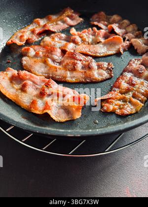 Schneidet gebratenen Speck in einer Pfanne. Leckerer gebratener Speck. Direkt darüber. Stockfoto