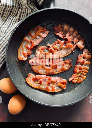 Schneidet gebratenen Speck in einer Pfanne. Leckerer gebratener Speck. Direkt darüber. Stockfoto