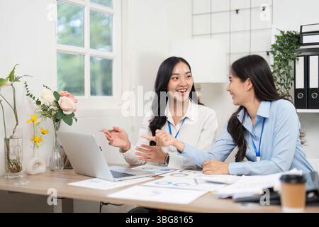 Zusammenarbeit im Büro. Zwei professionelle Frauen diskutieren Projektdetails an einem Schreibtisch. Stockfoto