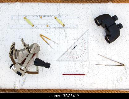 Navigationstools befinden sich auf der Navigationskarte. Sextant, Plotter, Teiler, Lineal und Fernglas. Stockfoto