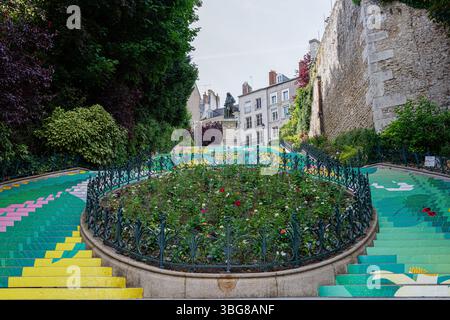 Farbenfroh bemalte Treppen mit Blumenmotiven in einer urbanen Umgebung, umgeben von Grün und historischen Gebäuden, schaffen eine lebendige und künstlerische Atmosphäre Stockfoto