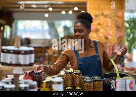 Ladenbesitzer arrangierte Konservengläser im Zero Waste Store Stockfoto