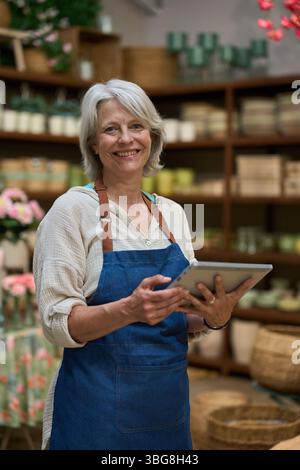 Senior Florist mit digitalem Tablet im Blumengeschäft Stockfoto