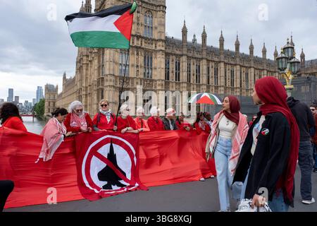 Rot gekleidete Demonstranten treffen sich zu einer Demonstration der Roten Linie für Palästina, die das Parlament umgab, die von der Palästinensischen Solidaritätskampagne am 4. Juni 2025 in London, Großbritannien, organisiert wurde. Es findet während der Fragen des Premierministers statt, in denen ein vollständiges Waffenembargo und Sanktionen gegen Israel gefordert wurden. Stockfoto