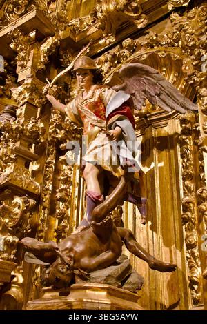 Eine Skulptur des Heiligen Michael, die ein Schwert auf Feuer schwindet, steht über dem Teufel in der Capilla de San Miguel Cáceres Co-Kathedrale der Heiligen Maria Caceres Spanien Stockfoto