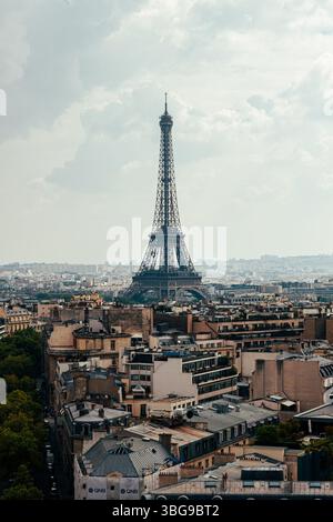 Der ikonische Eiffelturm erhebt sich über dem weitläufigen Stadtbild von Paris unter einem bewölkten Himmel. Stockfoto