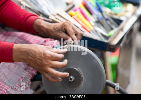 Schärfen der Messer Klinge auf einem Schleifstein, indischer Messerschärfer im Einsatz, Rad über Pedale angetrieben, Kultur Indiens Stockfoto