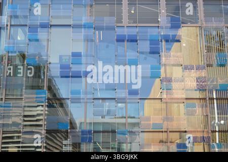 Industrieller Abstract der Gebäudereflexion in der Glasfensterfassade. CAOS von Formen, Farben und Stücken auf blauem, sonnigem Hintergrund. Lustiger Eindruck. Stockfoto