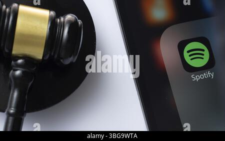 Dhaka, Bangladesch, 18. März 2025: Eine Nahaufnahme eines iPad-Bildschirms, auf dem die spotify-App neben einem Hammer eines Richters angezeigt wird Stockfoto