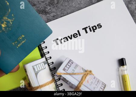 Reisetipps schreiben auf Buch isoliert auf Holztisch. Mit Pass, Dollarscheine Stockfoto