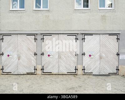 Füssen, Deutschland - 4. April 2016: Frontalansicht von drei nebeneinander liegenden Garagentoren in einem Hinterhof in Füssen Stockfoto