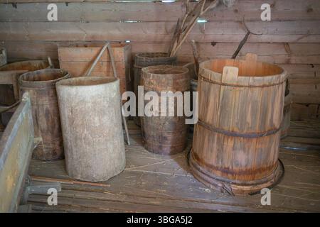 Ein Haufen alter Holzfässer stapelt sich in einem Raum. Die Fässer haben verschiedene Größen und Formen und scheinen alt und abgenutzt zu sein. Das Zimmer hat eine Stockfoto