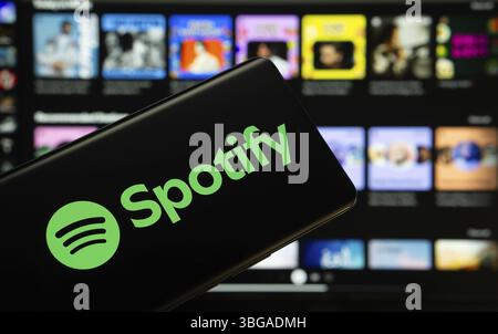 Dhaka, Bangladesch - 18. März 2025: Das Logo der spotify wird auf einem Smartphone-Bildschirm angezeigt, und die Website spotify ist auf einem Computer-Bildschirm sichtbar Stockfoto