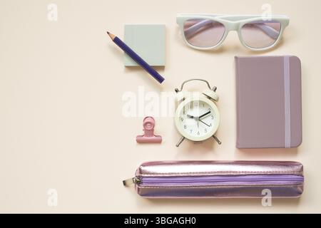 Helles lila Bürobedarf Schreibwaren auf rosa Schreibtischhintergrund. Flache Lage, Draufsicht Stockfoto