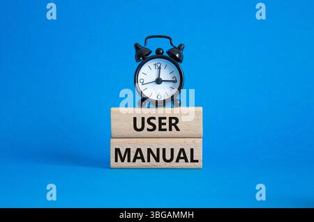 Symbol Benutzerhandbuch. Concept Words Benutzerhandbuch auf Holzblöcken. Wunderschöner blauer Hintergrund mit Wecker. Konzept des Geschäfts- und Benutzerhandbuchs. Spa kopieren Stockfoto