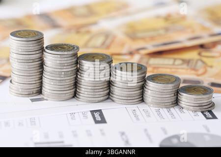 Polnische fünf Zloty-Münzen gestapelt. Euro-Banknoten als Hintergrund. Geldeinsparungen und Budgetkontrolle. Währungsumrechnungssymbol. Sicht der Wirtschaftskrise. Stockfoto