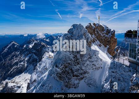 Touristen auf der Icy Gipfelplattform mit Blick auf das Goldene Kreuz auf der Zugspitze, Deutschland – 30. Mai 2025, Bayern, Deutschland Stockfoto