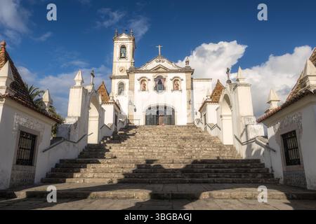 Blick auf die Treppe und Hauptfassade der Kirche Santo António dos Olivais in Coimbra, Portugal, beleuchtet von der Sonne mit blauem Himmel und Clou Stockfoto