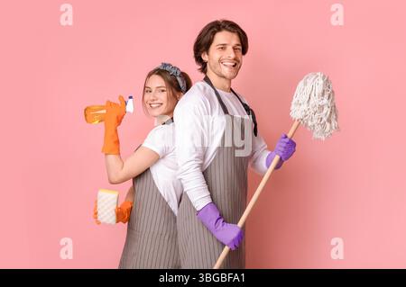 Professioneller Reinigungsservice. Lächelnder Mann Und Frau Mit Haushaltsgeräten In Den Händen Stockfoto