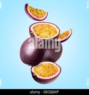 Köstliche reife Passionsfrüchte, die auf hellblauem Hintergrund fallen Stockfoto