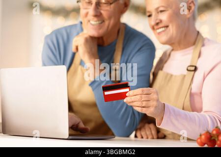 Ältere Paar Mit Kreditkarte Und Laptop Kauf Lebensmittel Im Innen Stockfoto