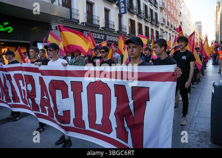 Madrid, Spanien – 23. Mai 2025: Rechtsextreme Demonstranten tragen ein „Remigración“-Banner und spanische Flaggen während eines von der Falange organisierten Marsches. Stockfoto