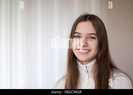 Porträt eines fröhlichen Mädchens mit langen braunen Haaren. Leerzeichen für Text. Stockfoto