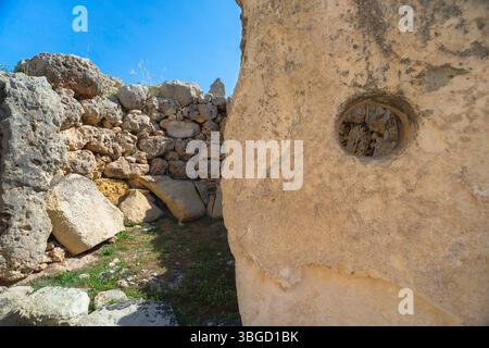 Megalithtempel Malta, Blick auf einen riesigen, aufrechten Stein mit einer kreisförmigen Öffnung, die vermutlich als Holzstützplatz fungiert, Ggjantija, Gozo Malta Stockfoto