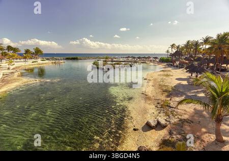 Kristallklares türkisfarbenes Wasser hüllt sanft an die Sandküste eines wunderschönen Strandes in puerto aventuras, einem luxuriösen Resort an der riviera May Stockfoto