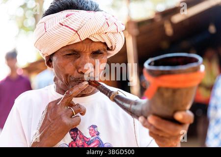 Lokale Musiker spielen auf traditionellen Instrumenten, während sie an einem Hochzeitstag im abgelegenen Teil von Orissa in Indien feiern. Stockfoto